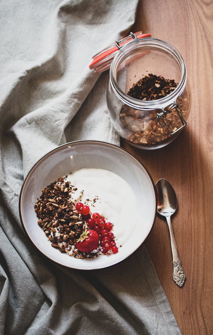 Delicious and nutritious breakfast with yogurt, berries, and granola presented in a rustic setting.